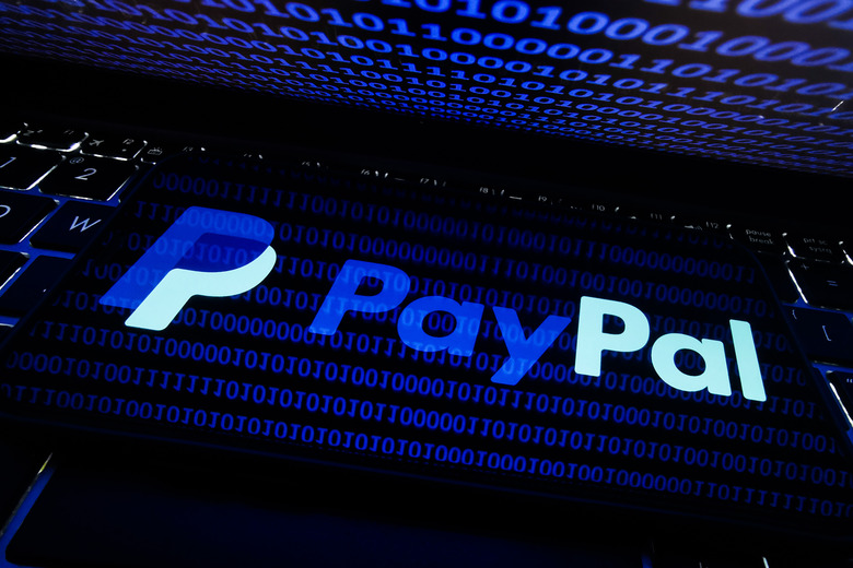 PayPal logo displayed on a phone screen is seen with binary code displayed on a laptop screen in this illustration photo taken in Krakow, Poland on August 17, 2021. (Photo by Jakub Porzycki/NurPhoto via Getty Images)