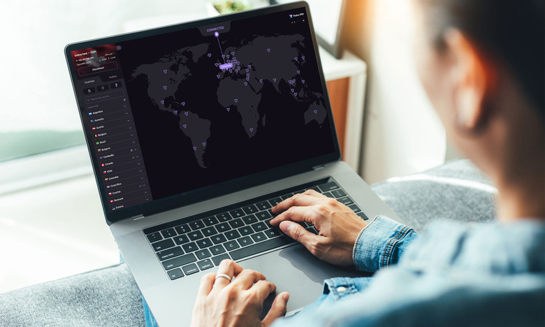 A person uses Proton VPN on a laptop the image of a map is on screen with purple dots indicating server locations. 