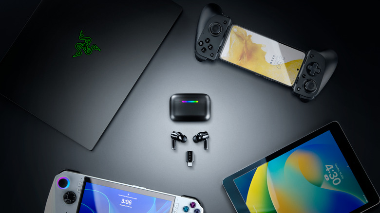 Earbuds surrounded by devices.
