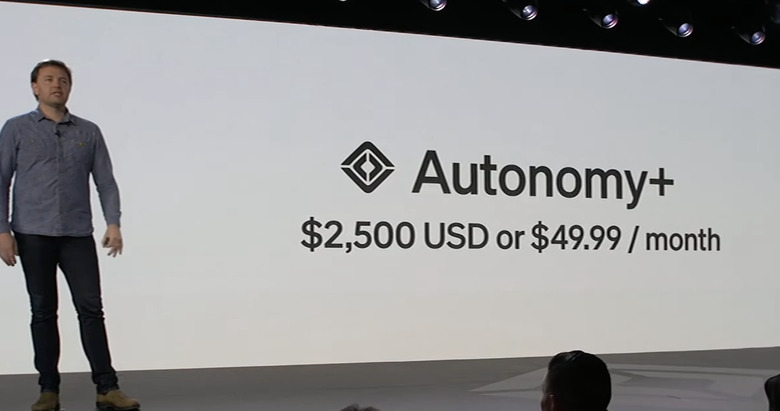 Rivian's James Philbin standing next to a screen saying 