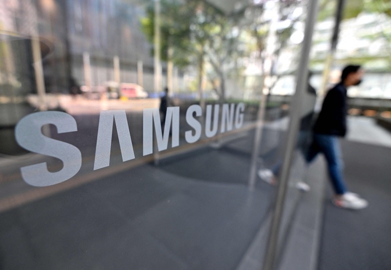 A man walks past the Samsung logo displayed on a glass door at the company's Seocho building in Seoul on April 7, 2023. - Samsung Electronics said on April 7 it expected first-quarter operating profits to plunge over 95 percent on-year to a 14-year low, as memory chip sales were hammered by a global downturn. (Photo by Jung Yeon-je / AFP) (Photo by JUNG YEON-JE/AFP via Getty Images)