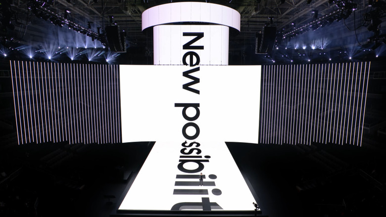 Stage with huge ultrawide screen on the back, and a perpendicular screen stretching above and below it onto the runway. 