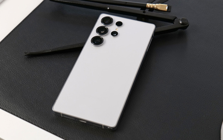 A white phone on a black surface.