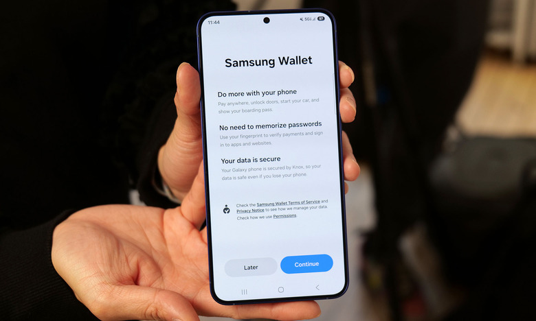 A Galaxy S25 held in two hands, with the Samsung Wallet app on its screen.