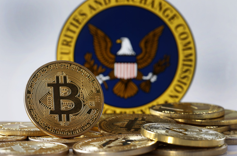 PARIS, FRANCE - JANUARY 10: In this photo illustration, a visual representation of the digital cryptocurrency Bitcoin is displayed in front of Securities and Exchange Commission (SEC) logo on January 10, 2024 in Paris, France. The first American Bitcoin ETF could be authorized by the SEC (Commissioner of the American Stock Exchange) as early as Wednesday January 10, 2024. Around ten of the largest financial asset managers in the world have filed an application with the SEC to launch a Bitcoin ETF. After blocking the entry of bitcoin on Wall Street for more than 10 years, the Securities and Exchange Commission (SEC) should, barring any drama, authorize it on Wednesday by giving the green light to exchange-traded funds (ETFs) invested in bitcoin. (Photo illustration by Chesnot/Getty Images)