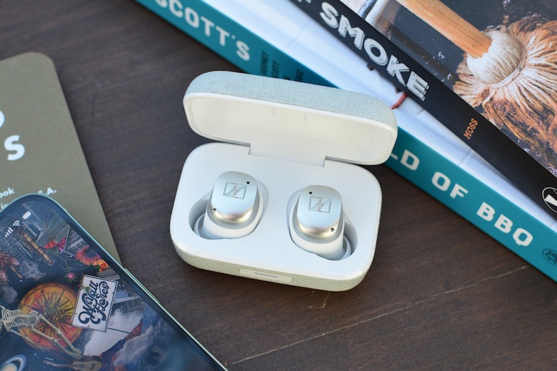 White/silver Sennheiser Momentum True Wireless 4 earbuds sitting in their case with the lid open.