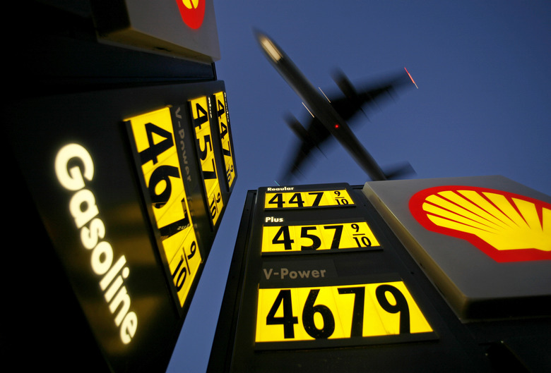 Gasoline prices are advertised at a gas station near Lindbergh Field as a plane approaches to land in San Diego, California June 1, 2008. REUTERS/Mike Blake      (UNITED STATES)