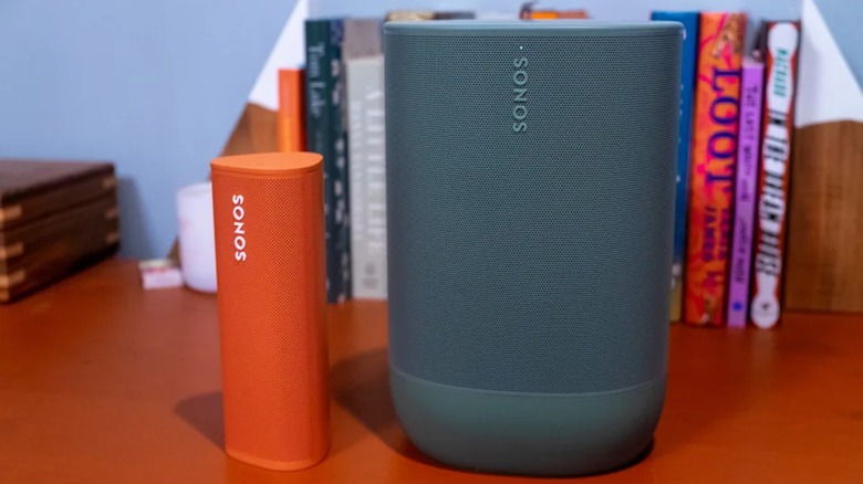 An orange Sonos Roam speaker next to a grey Sonos Move 2.