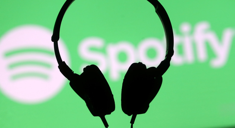 A headset is seen in front of a screen projection of Spotify logo, in this picture illustration taken April 1, 2018. REUTERS/Dado Ruvic/Illustration