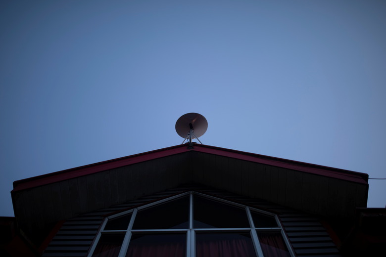 The Starlink antenna is seen on the roof of the John F Kennedy School located in the village of Sotomo, outside the town of Cochamo, Los Lagos region, Chile, August 7, 2021. Picture taken August 7, 2021. Sotomo is one of two places in Chile to be chosen for a pilot project run by billionaire Elon Musk to receive free internet for a year. The signal is received via a satellite dish installed on the school's roof, which transmits through a Wi-Fi device. REUTERS/Pablo Sanhueza         SEARCH 