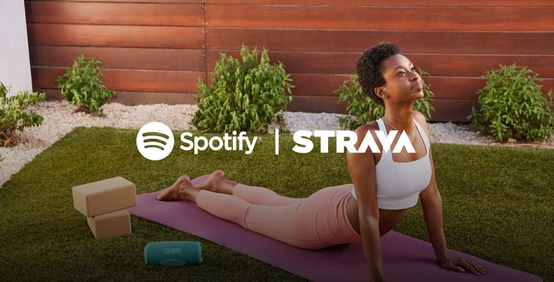 A person does yoga in an outdoor garden with the Spotify and Strava logos laid on top of her. 