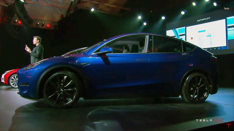 Tesla CEO Elon Musk stands behind the Model Y at its 2019 unveiling.
