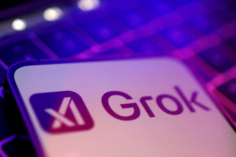 An image shows Grok and the X logo over a blurred, backlit keyboard in the background