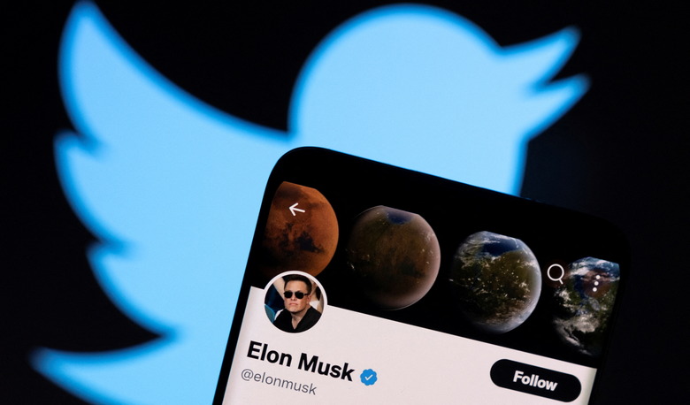 Elon Musk's twitter account is seen on a smartphone in front of the Twitter logo in this photo illustration taken, April 15, 2022. REUTERS/Dado Ruvic/Illustration