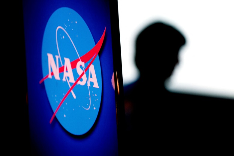 The silhouette of US engineer and NASA astronaut Megan McArthur is seen past the NASA logo in the Webb Auditorium at NASA headquarters in Washington, DC, on June 7, 2022. (Photo by Stefani Reynolds / AFP) (Photo by STEFANI REYNOLDS/AFP via Getty Images)