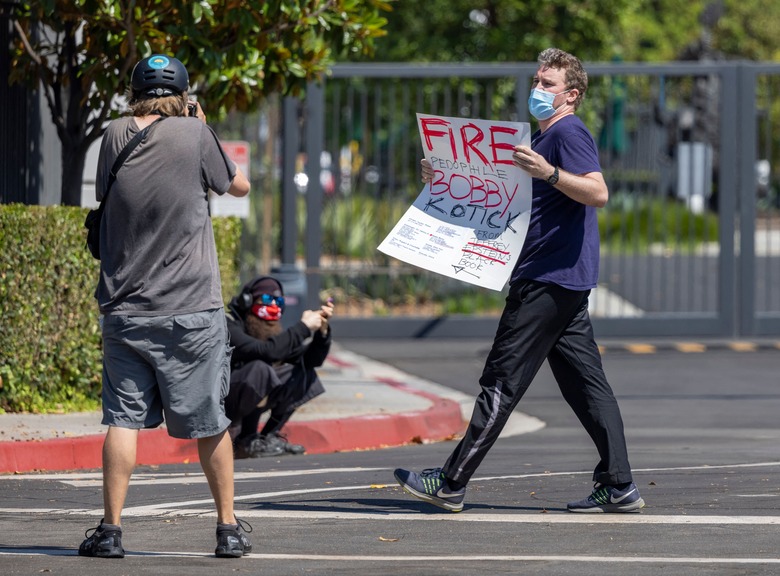 A man carrying a sign accusing Activision Blizzard CEO Robert A. Kotick of pedophilia is ordered by protest organizers to leave the area as employees of the video game holding company, Activision Blizzard, hold a walkout and protest rally to denounce the companys response to a California Department of Fair Employment and Housing lawsuit and to call for changes in conditions for women and other marginalized groups, in Irvine, California, on July 28, 2021.  (Photo by DAVID MCNEW / AFP) (Photo by DAVID MCNEW/AFP via Getty Images)