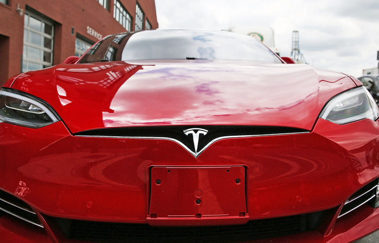A closeup of a red Tesla's front grill / bumper.