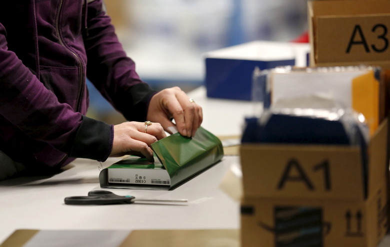 A worker gift wraps a holiday order for a customer at the Amazon Fulfillment Center in Tracy, California, November 29, 2015. U.S. holiday shopping is on track for a modest 3.7 percent rise this year after strong turnout during the Thanksgiving and Black Friday weekend and thanks to strong online sales, the National Retail Federation said on Sunday after releasing an annual consumer poll. REUTERS/Fred Greaves