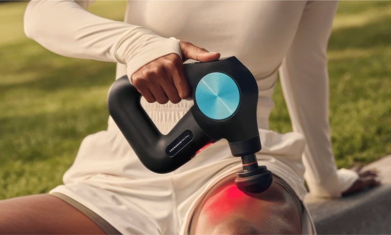 Photo of an athlete massaging their thigh with the Theragun Pro Plus massage gun.