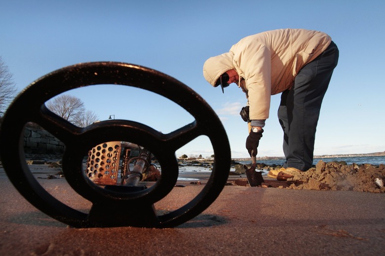With metal detector on the sand next to him, Daniel Berube of Ashley Lane in Portland digs for trea...