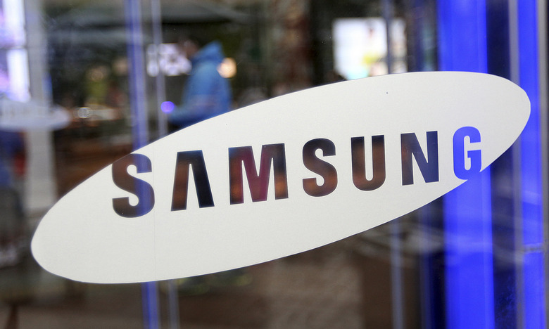 A man walks by the entrance to Samsung Electronics Co.'s showroom at its headquarters in Seoul, South Korea, Friday, July 6, 2012. Samsung, the world's largest maker of memory chips, mobile phones, flat-screen panels and televisions, said Friday that its preliminary second-quarter operating profit jumped nearly 80 percent from a year ago to a record high. (AP Photo/Hye Soo Nah)