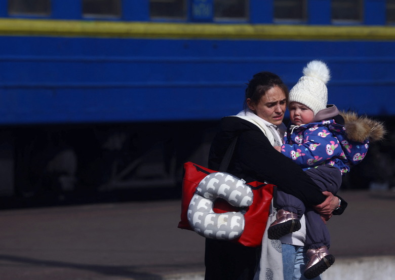 A mother holds her girl after arriving by a train from north eastern Ukraine transporting refugees fleeing the ongoing Russian invasion, at the main train station in Lviv, Ukraine, March 12, 2022.  REUTERS/Kai Pfaffenbach