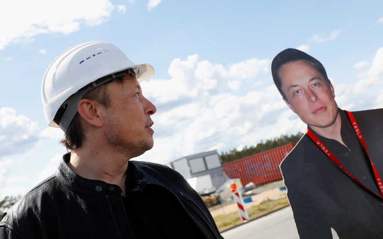 SpaceX founder and Tesla CEO Elon Musk looks at a cutout of him as he visits the construction site of Tesla's gigafactory in Gruenheide, near Berlin, Germany, May 17, 2021. REUTERS/Michele Tantussi