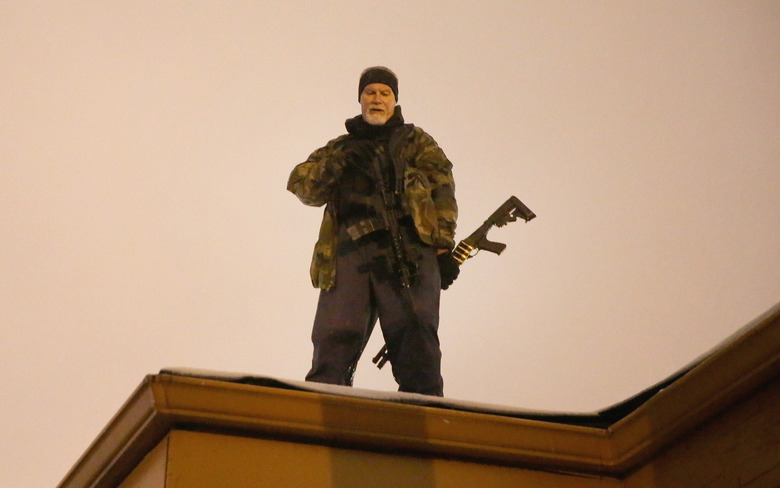 FERGUSON, MO - NOVEMBER 26:  John Karriman. a volunteer from Oath Keepers, stands guard on the rooftop of a  business on November 26, 2014 in Ferguson, Missouri. Demonstrators looted and burned down several businesses along the street on Monday after the grand jury announced its decision in the Michael Brown case. Brown, an 18-year-old black man, was killed by Darren Wilson, a white Ferguson police officer, on August 9. (Photo by Scott Olson/Getty Images)