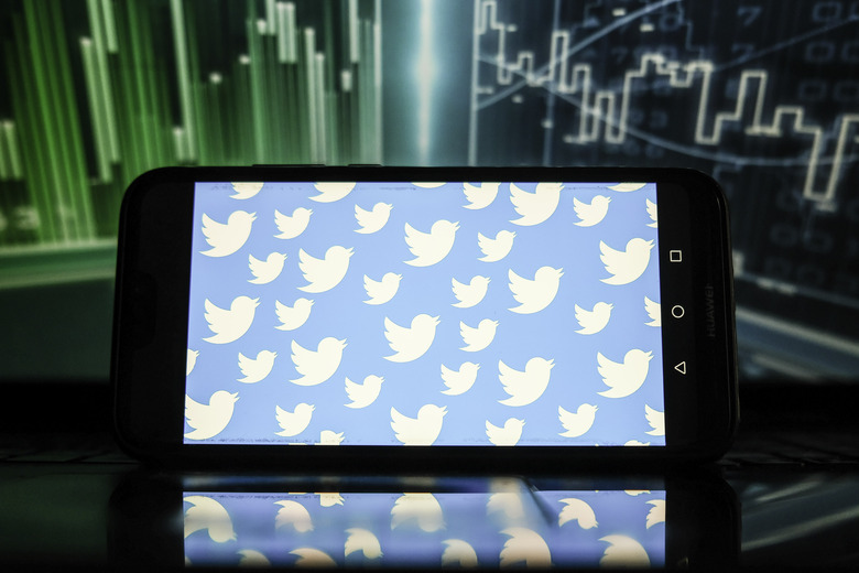POLAND - 2022/01/21: In this photo illustration, Twitter logos displayed on a smartphone with a stock market graphic in the background. (Photo Illustration by Omar Marques/SOPA Images/LightRocket via Getty Images)
