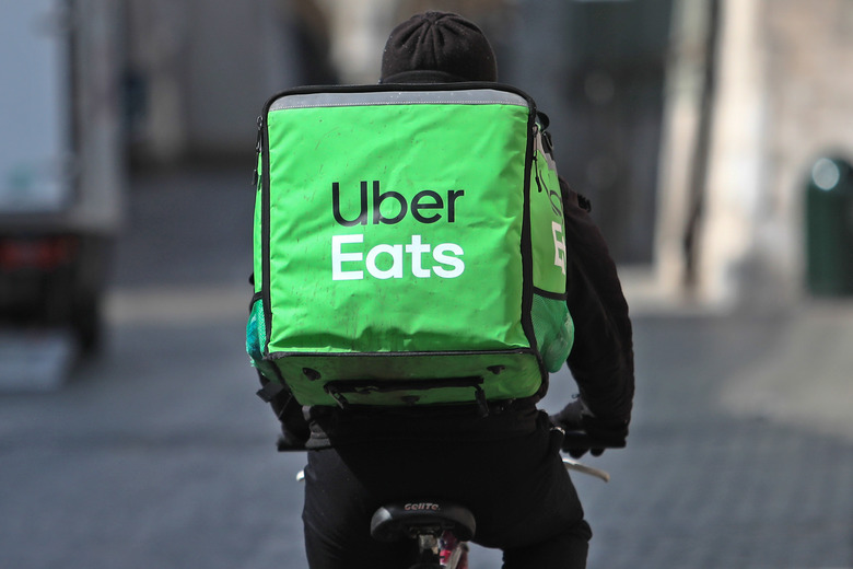 An Uber Eats bike delivery worker pedals away to their next delivery.