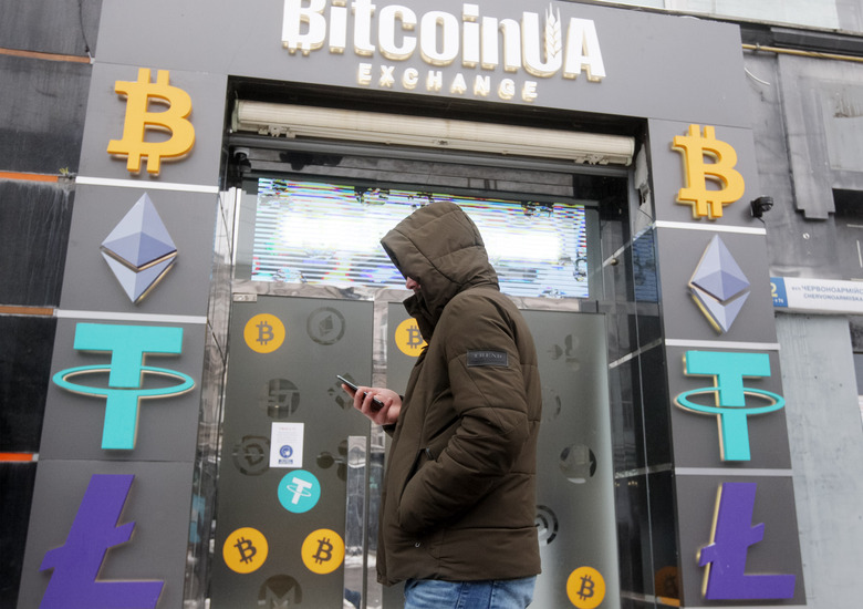 A man walks past a cryptocurrency exchange point in the center of Kyiv, Ukraine on 24 January 2022. Bitcoin dropped below $34 000, to six-month low, as fears of war in Ukraine shake stock markets, according to media. (Photo by STR/NurPhoto via Getty Images)
