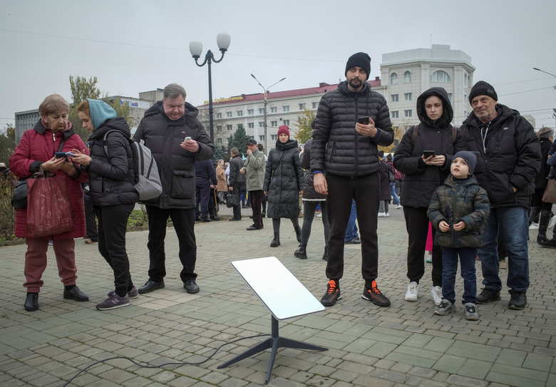 Local residents  use a Starlink terminal after Russia's retreat from Kherson, in central Kherson, Ukraine November 12, 2022.  REUTERS/Lesko Kromplitz