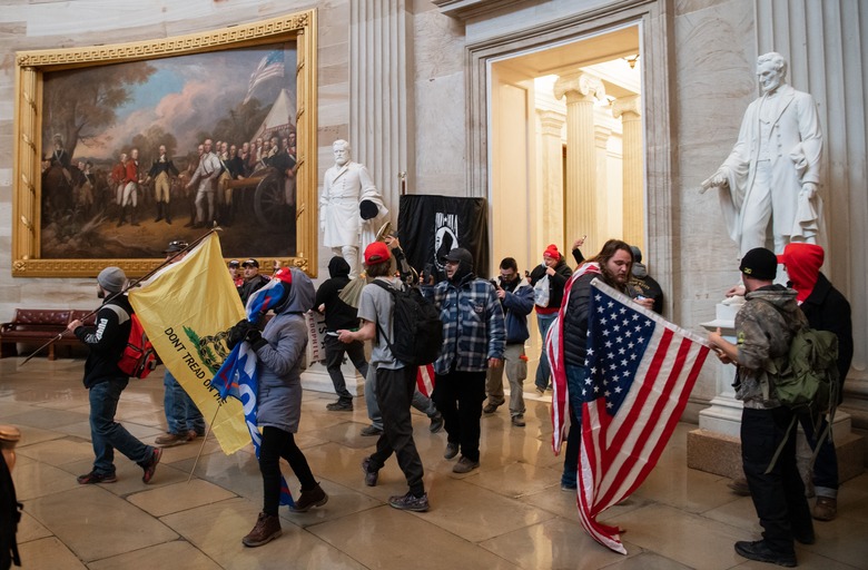 (FILES) Supporters of US President Donald Trump walk around in the Rotunda after breaching the US Capitol in Washington, DC, January 6, 2021. - The demonstrators breeched security and entered the Capitol as Congress debated the 2020 presidential election Electoral Vote Certification. (Photo by SAUL LOEB / AFP) (Photo by SAUL LOEB/AFP via Getty Images)
