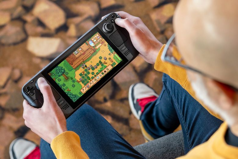A gamer playing Stardew Valley on the discontinued LCD model of the Steam Deck.