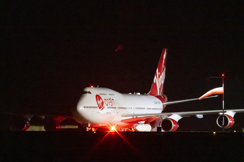 NEWQUAY, ENGLAND - JANUARY 09: A general view of Cosmic Girl, a repurposed Boeing 747 aircraft carrying the LauncherOne rocket under its left wing, as final preparations are made at Cornwall Airport Newquay on January 9, 2023 in Newquay, United Kingdom. Virgin Orbit launches its LauncherOne rocket from the spaceport in Cornwall, marking the first ever orbital launch from the UK. The mission has been named Start Me Up after the Rolling Stones hit. (Photo by Matthew Horwood/Getty Images)