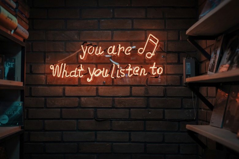 A neon sign on a wall, reading, 