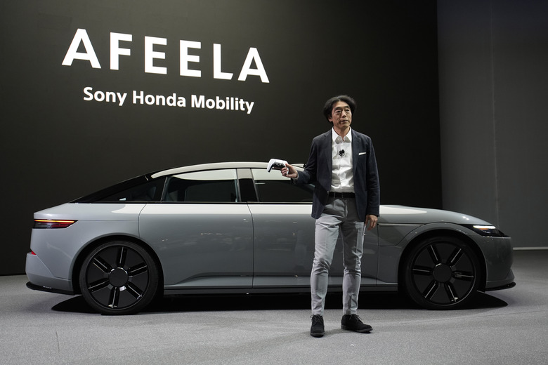 Izumi Kawanishi, president and COO of Sony Honda Mobility Inc., holds up a PlayStation controller after using it to drive an Afeela EV onto the stage during a Sony press conference ahead of the CES tech show Monday, Jan. 8, 2024, in Las Vegas. (AP Photo/John Locher)