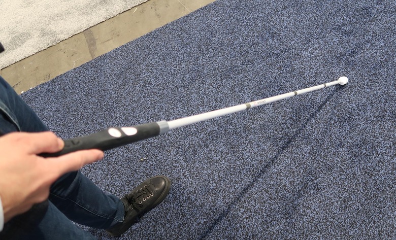 A person uses the Wewalk Smart Cane 2 to find their way through a CES booth.