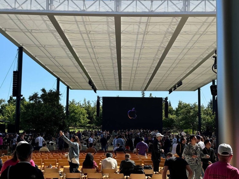 The WWDC 2024 stage at a distance, with rows of seats in between. People are standing around.