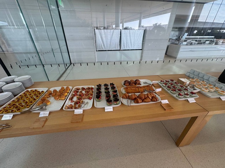 A series of plates on a wooden table, each carrying a different set of food. There are little cards in front of each dish.