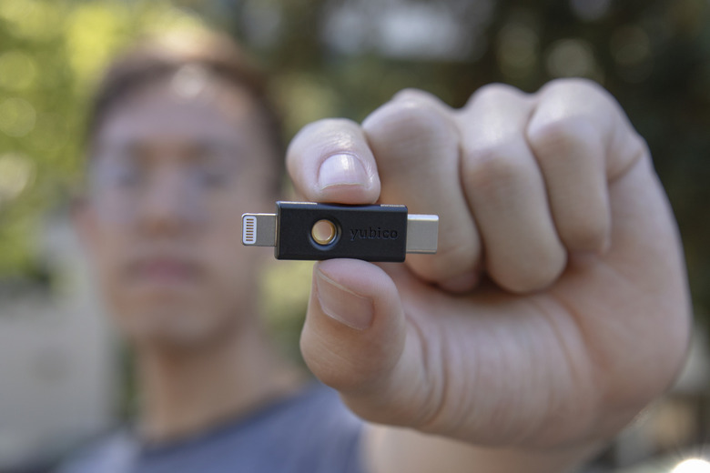 A small device with held by a person in the background.