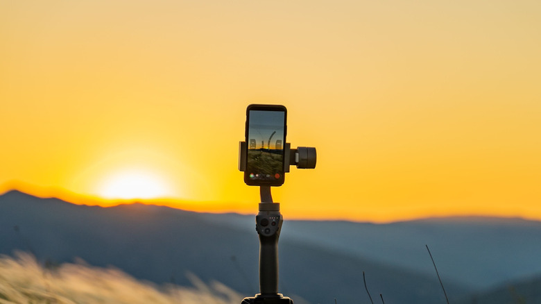 A scenic sunset in Montenegro captured with a smartphone on a tripod in a grassy field.