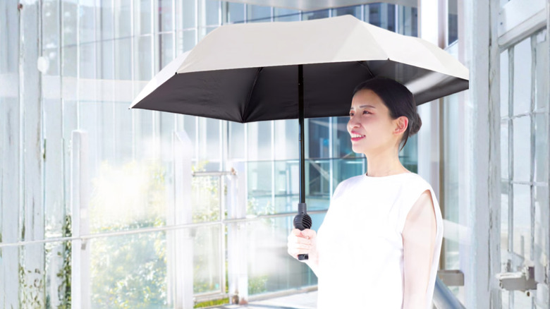 Woman using the Thanko Fanbrella POLE PLUS outdoors.