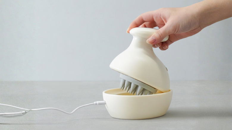 Person setting the TeteMousse onto its charger.