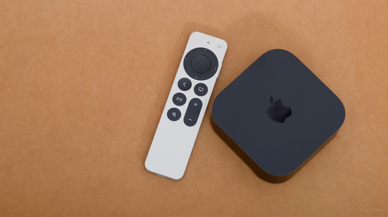 An Apple TV device with remote sitting on a table