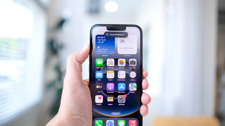 A hand holding an iPhone 16e