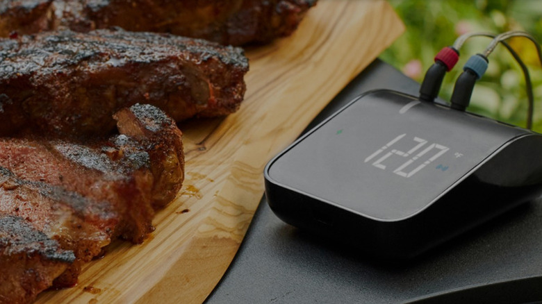 Weber Connect Smart Grilling Hub next to steaks ready to serve.