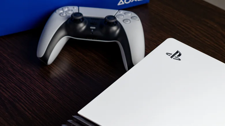 A zoomed in-shot of a PS5 and a DualSense controller on a table.
