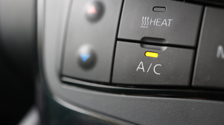 A car's interior showing the AC button turned on.