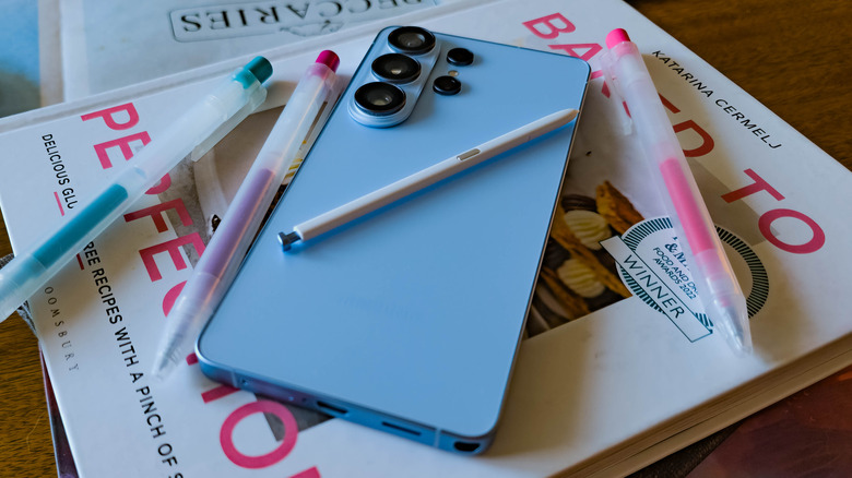 Samsung Galaxy S26 Ultra posed on table with books and pens.
